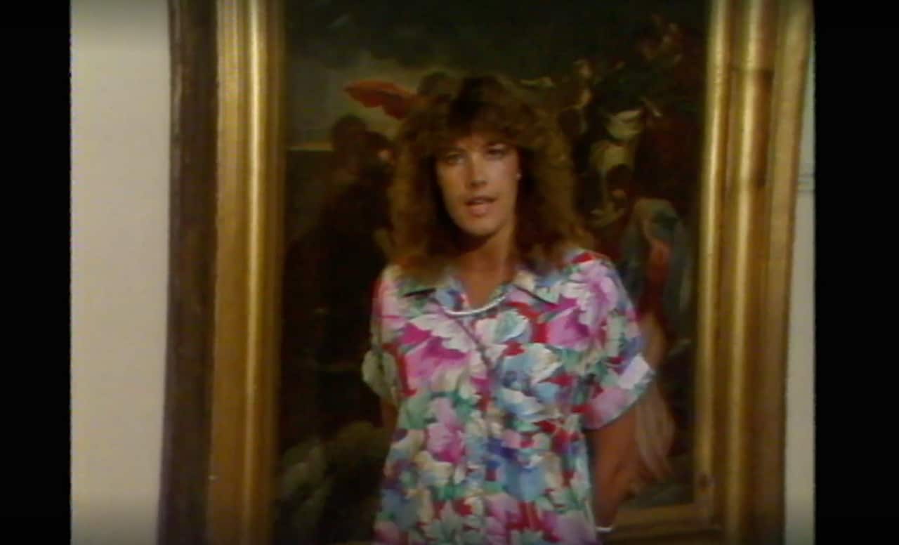 A woman standing in front of a painting and talking