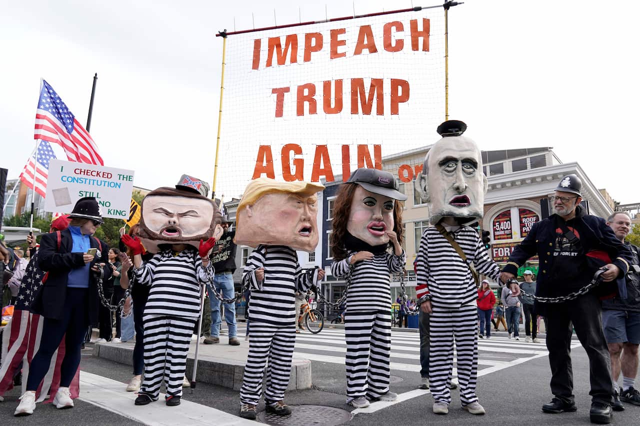 Demonstrators wear costumes and carry signs at a rally.