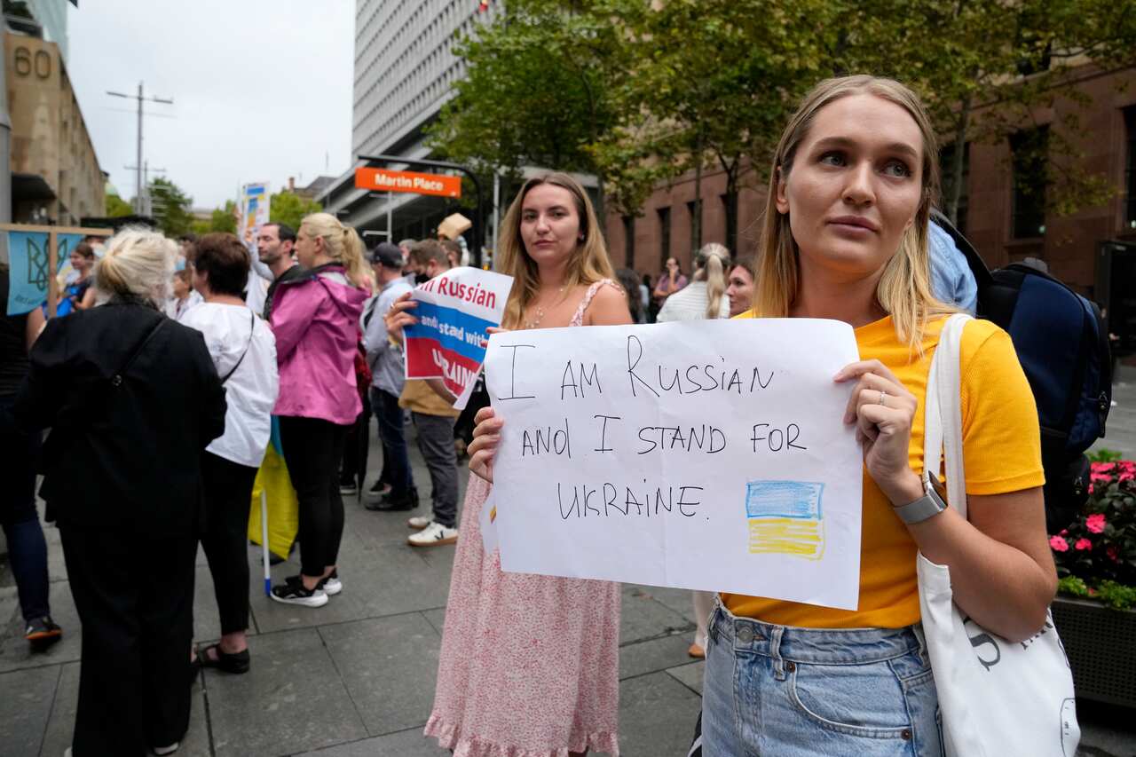 A Russian woman holds a sign during a rally in Sydney against the war in Ukraine