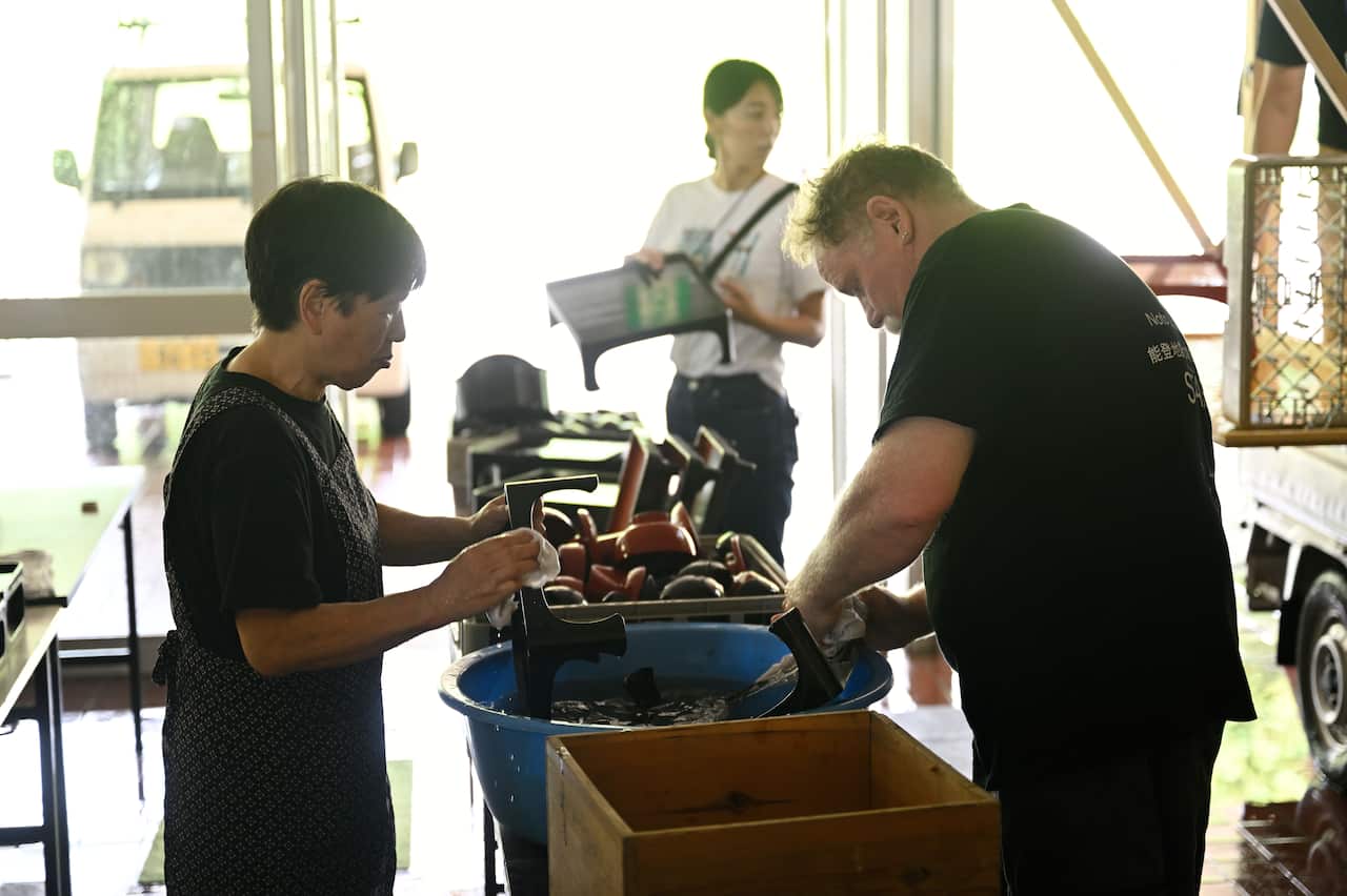 Washing wajima-nuri (Japanese lacquerware from Wajima) that were rescued from the damaged house of the earthquake