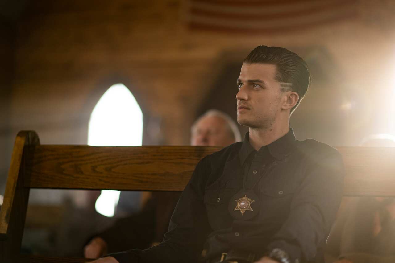 A police officer sits in a church pew
