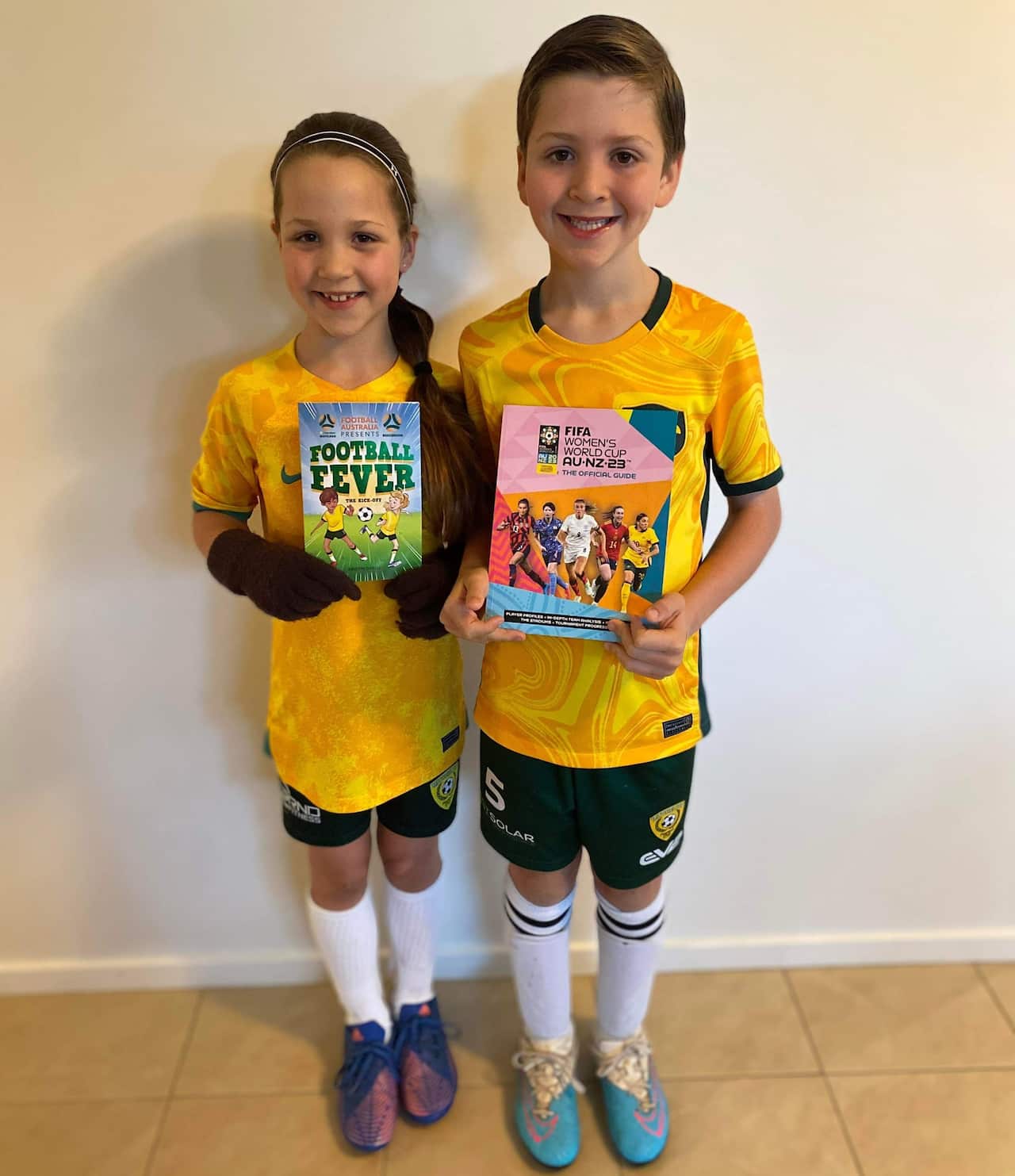 Two young children dressed in Matildas outfits.