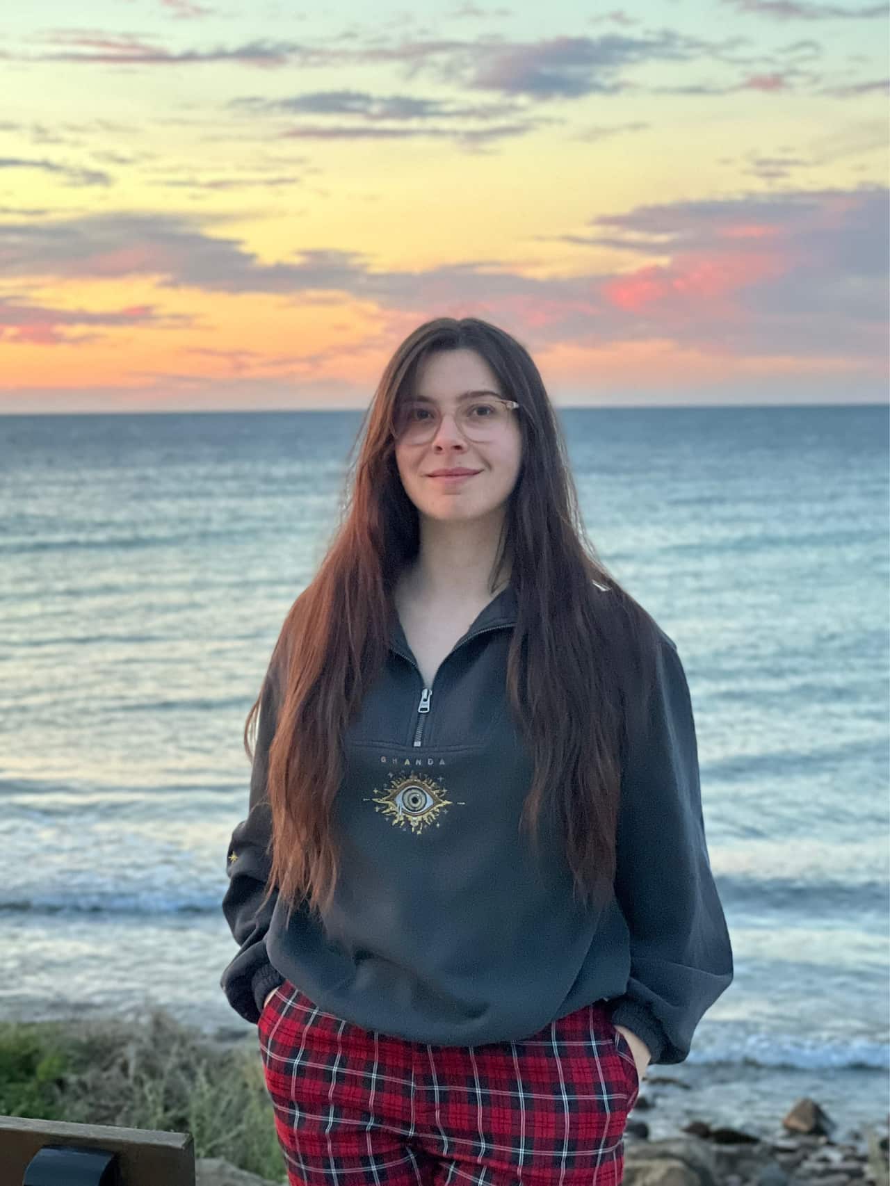Woman stands with the ocean behind her