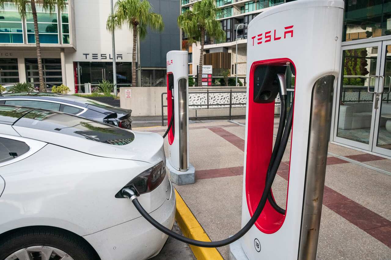 A car is being charged at a Telsa supercharger.