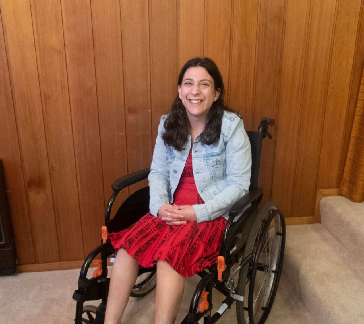 Laura Pettenuzzo in a wheelchair, smiling at the camera. 