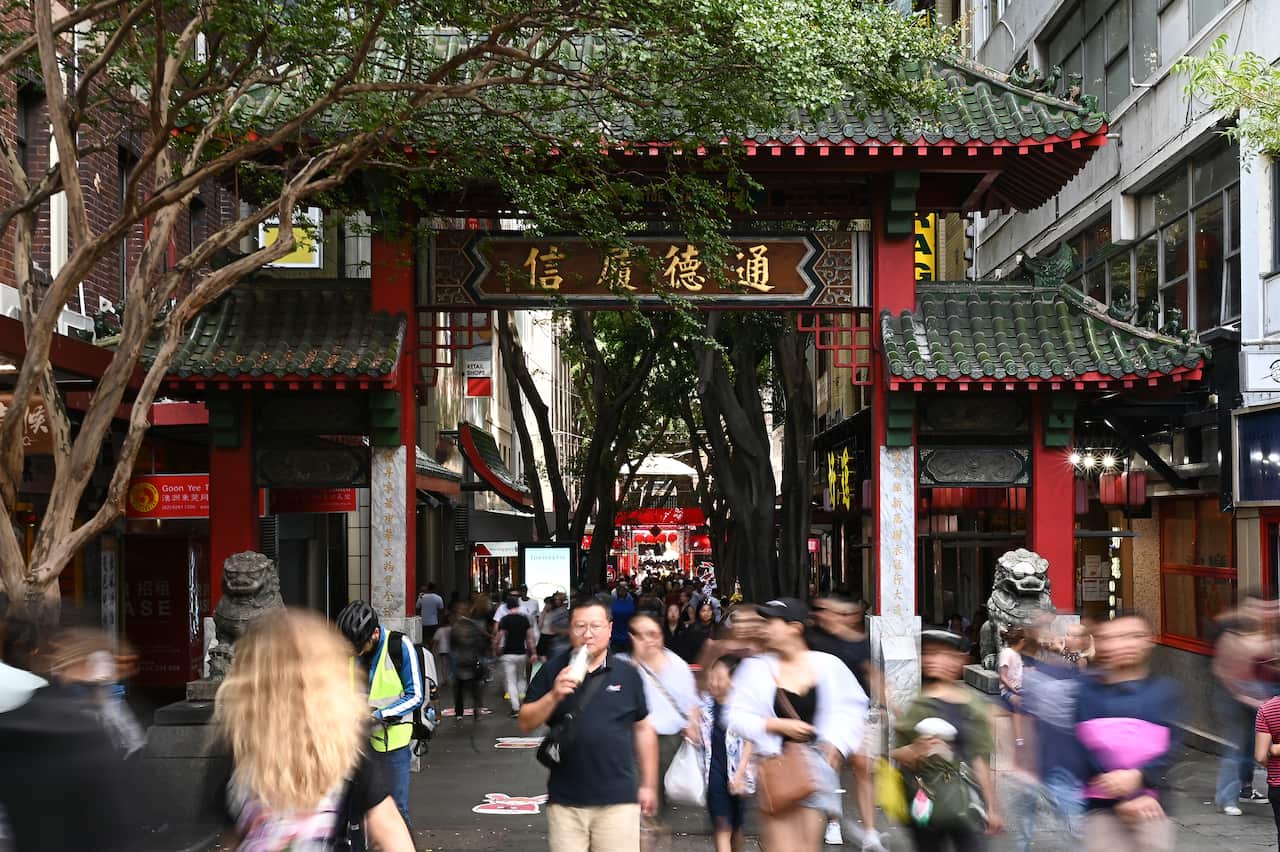 People walking through red Chinese ceremonial gates.