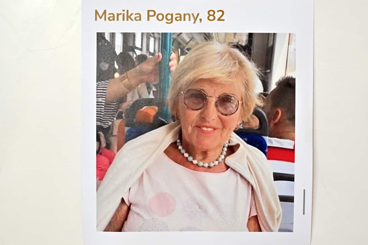 A photograph of a woman dressed in a white dress and pearls around her neck.