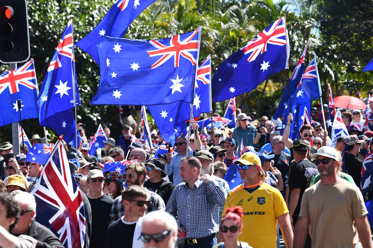 A large crowd of protesters, many holding Australian flags.