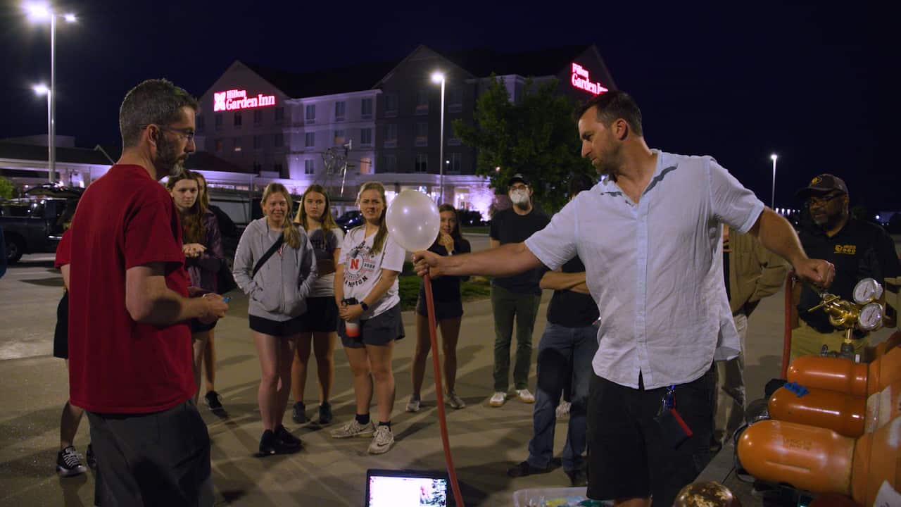 A man shows a crowd how to use a windsond.