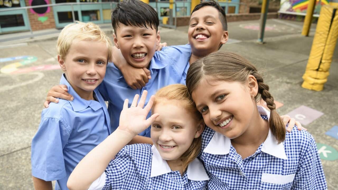 Two girls and three boys wearing school uniform smiling towards camera.jpg