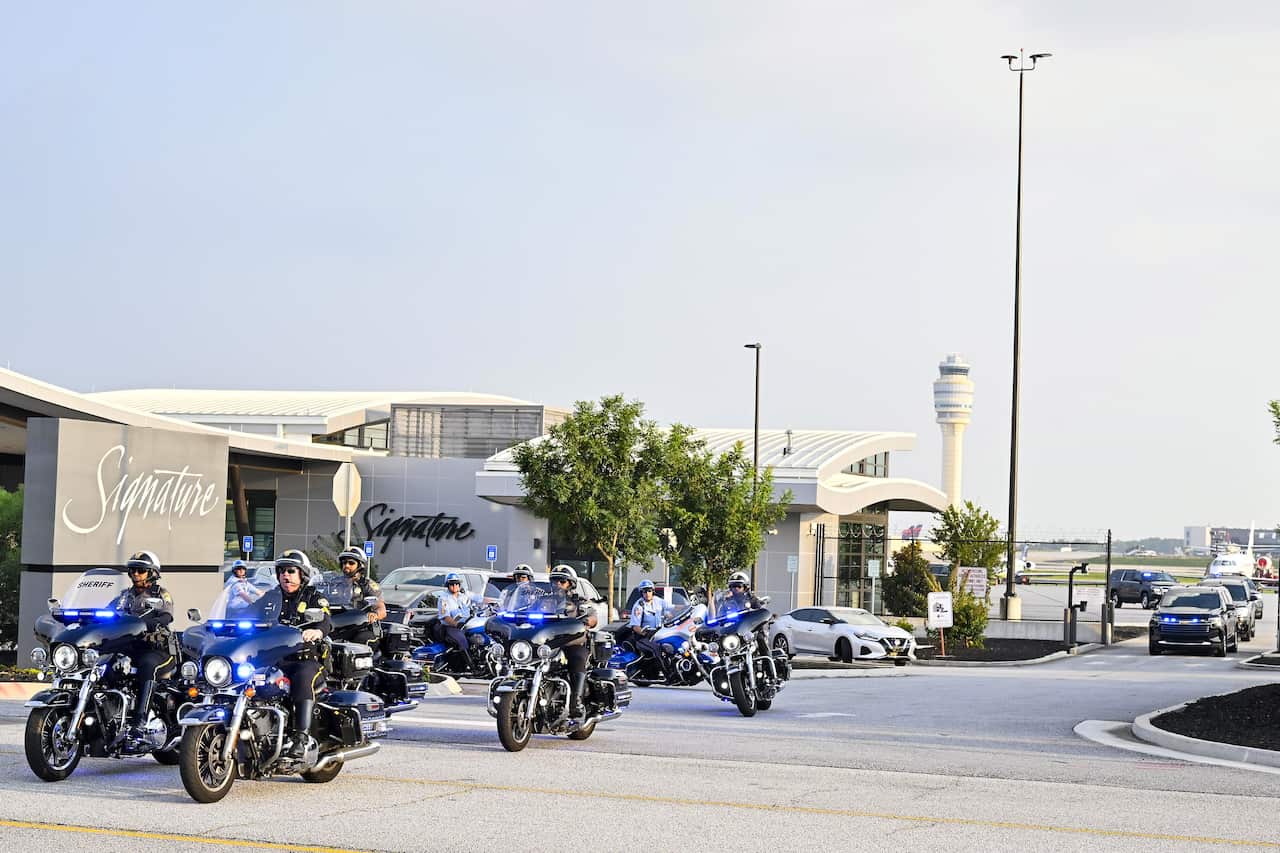 A police motorcade leading a vehicle from an airport.