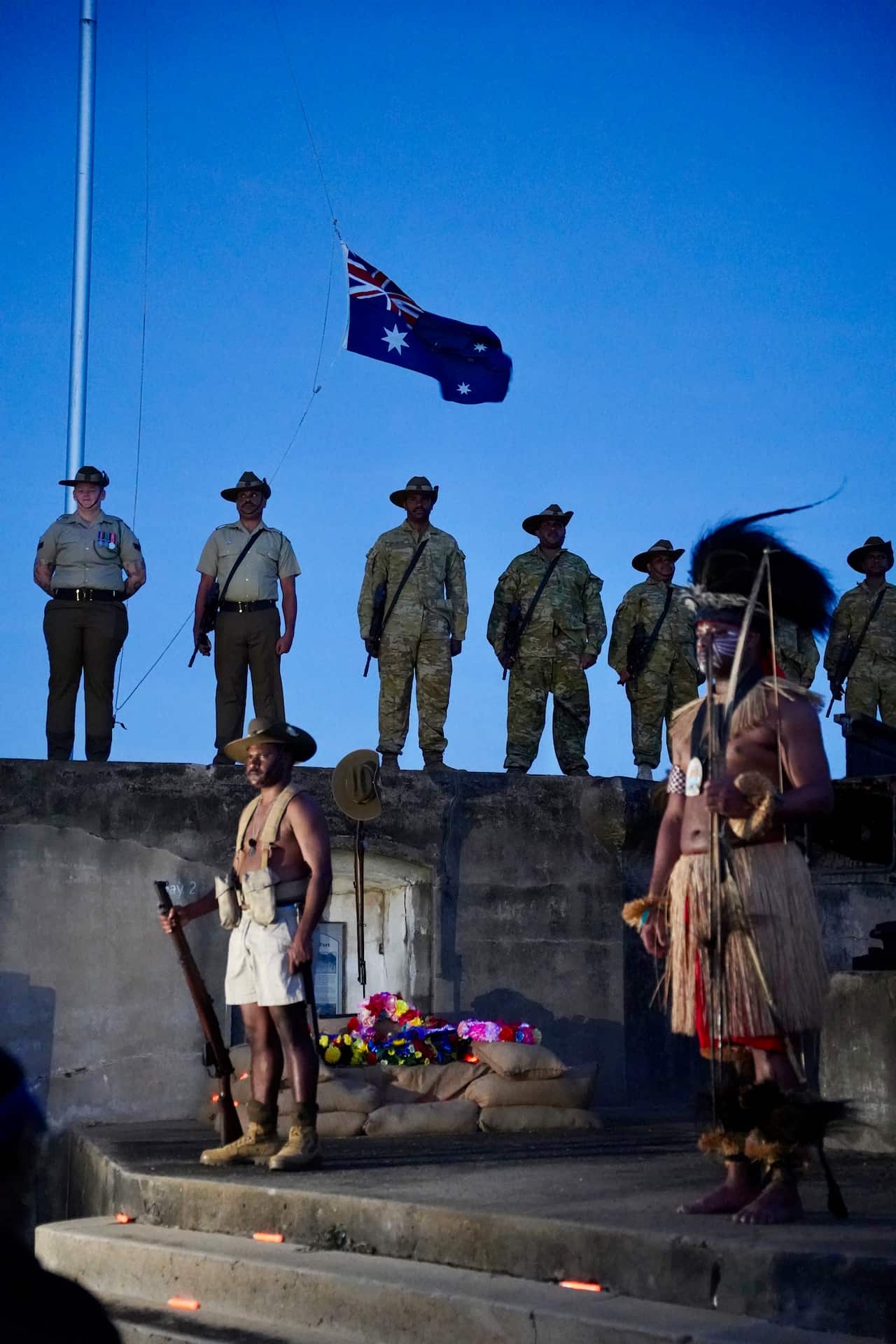 Los soldados asisten a una ceremonia de servicio al amanecer, algunos vistiendo ropas tradicionales.