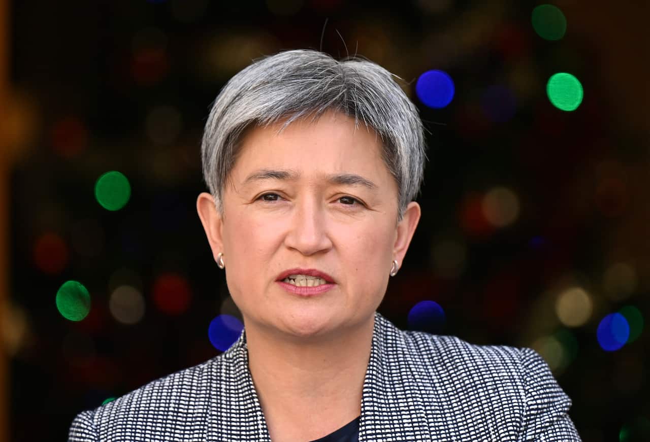 Woman in a suit jacket speaking.