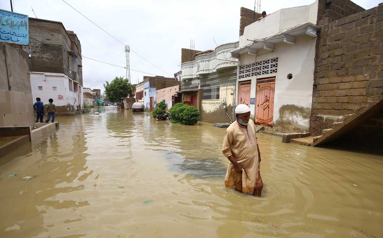 People make their way through a flooded area.