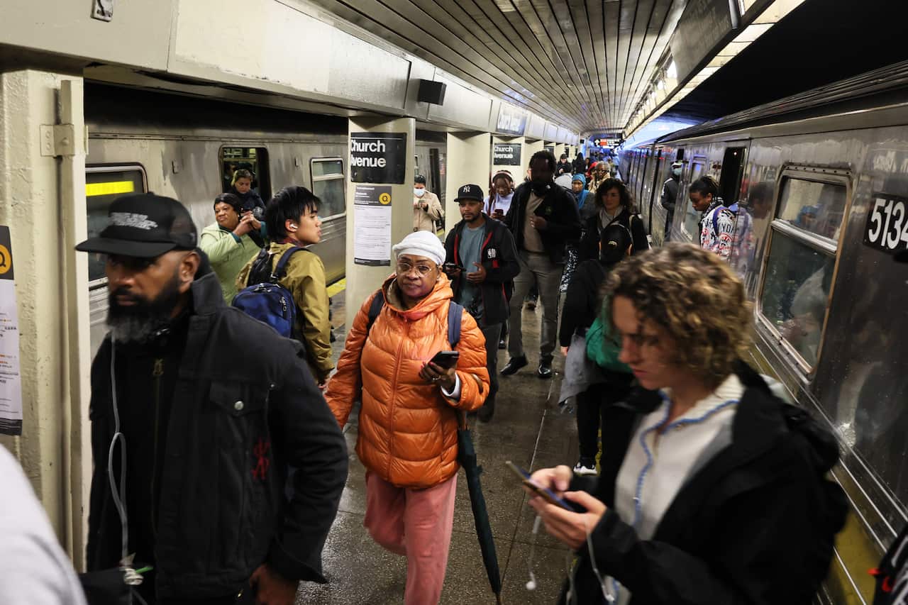 People walking on the platform at a subway station.