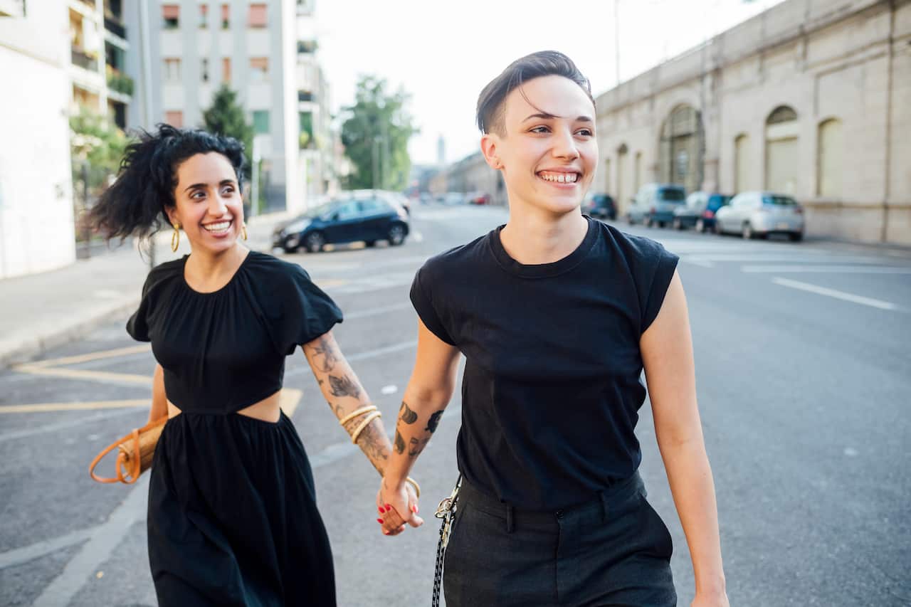 Smiling lesbian couple walking in city