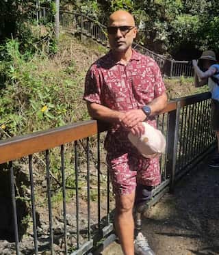 A man posing outside in bushland for a photo.