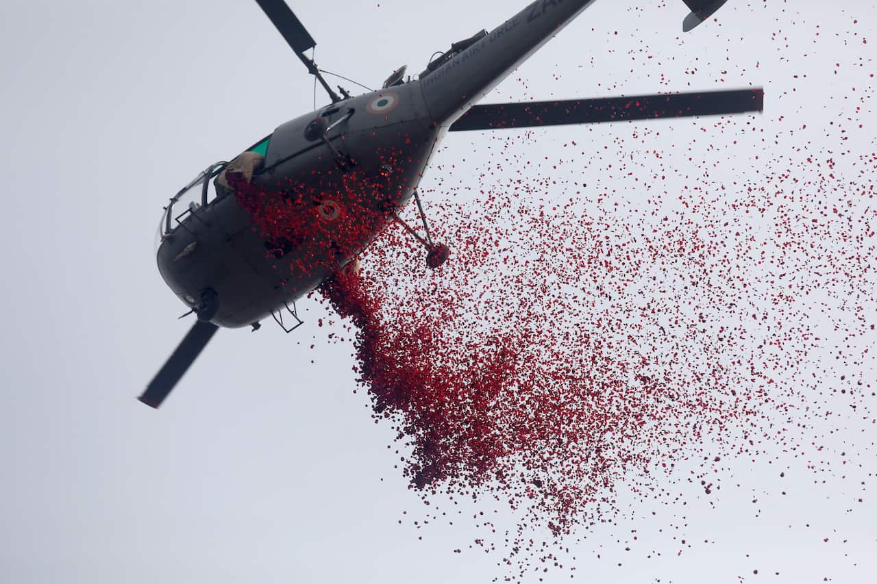 A helicopter drops rose petals. 