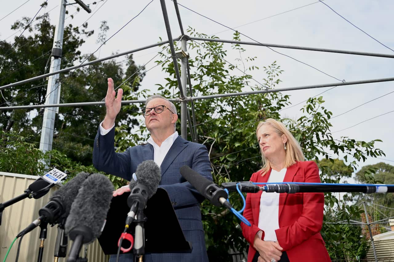 Two people speaking in a backyard.