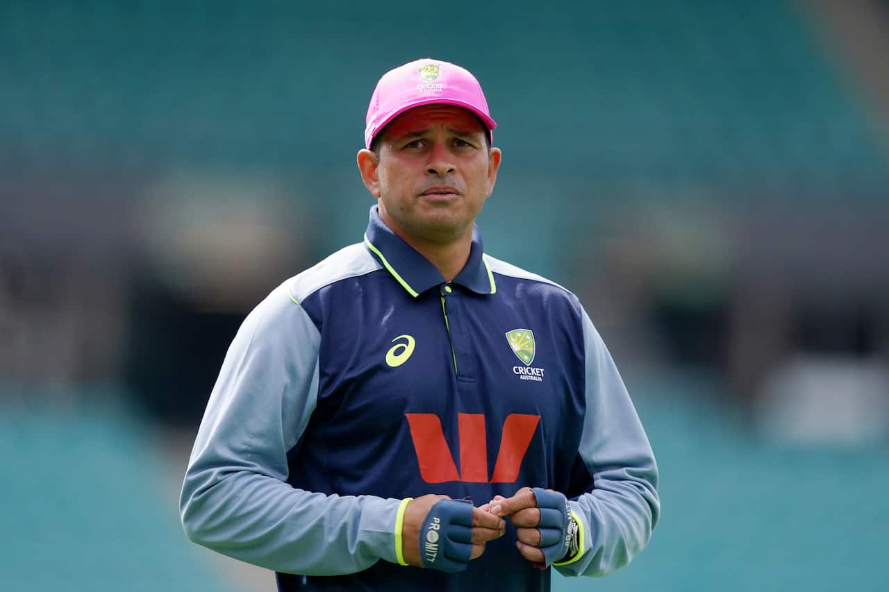 A man wearing a blue full-sleeve t-shirt and a pink cap.