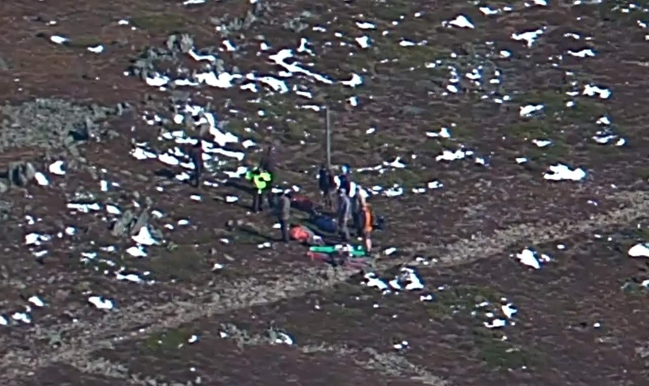 A group of hikers standing atop a mountain 