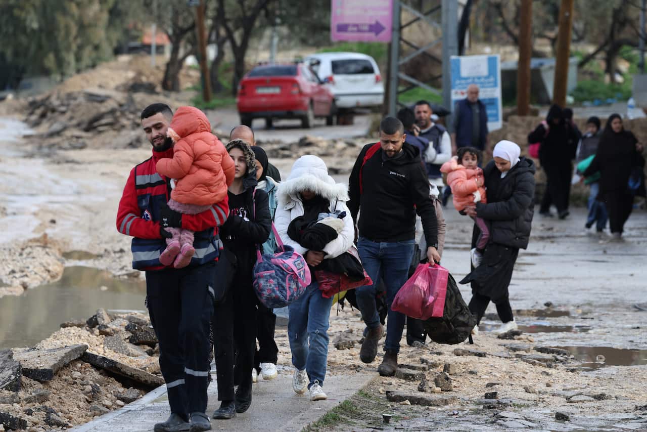A group of people, including children, walking along a road.