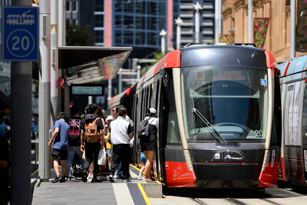 A group of people board a tram in the city