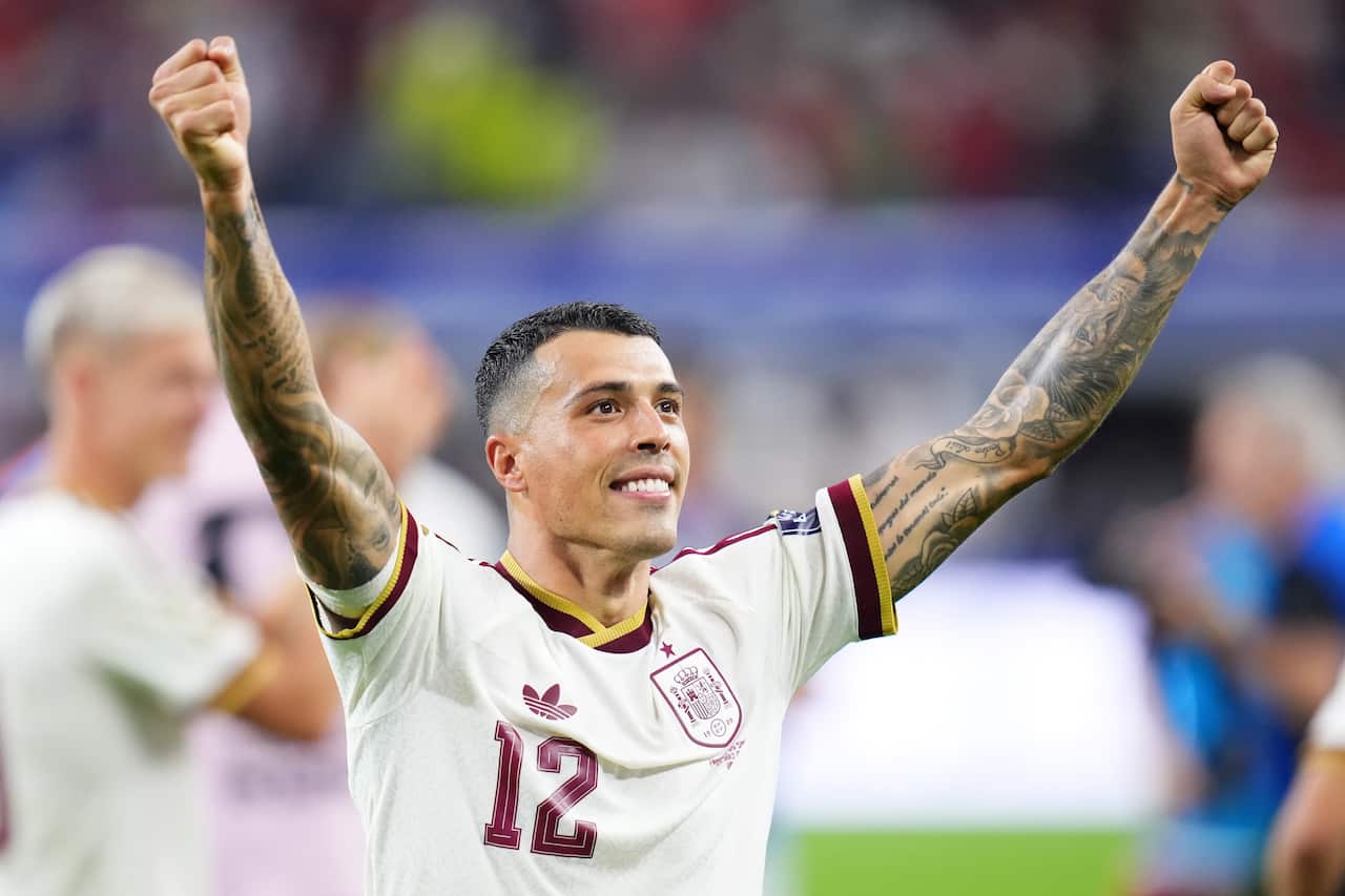 A Spanish footballer with his arm held up in celebration