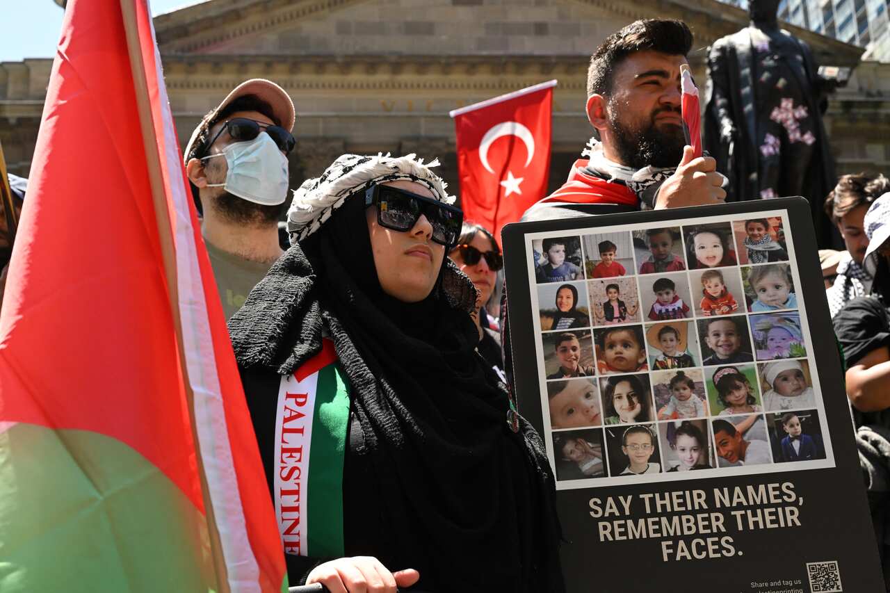 People hold a placard with children's face on it