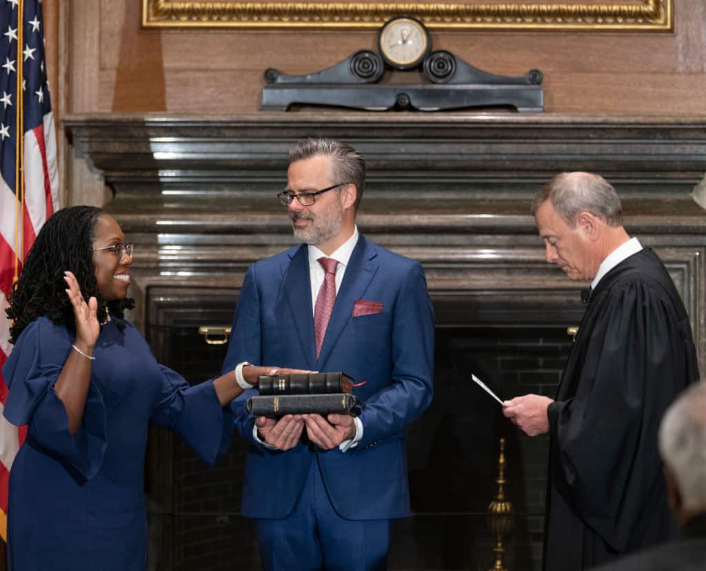 A woman smiles as she takes oath.