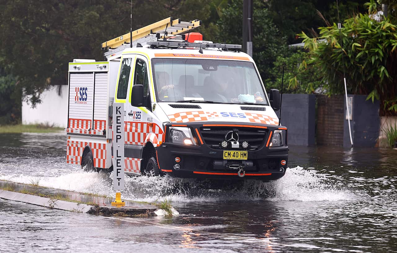 An emergency vehicle drives through flooded waters.
