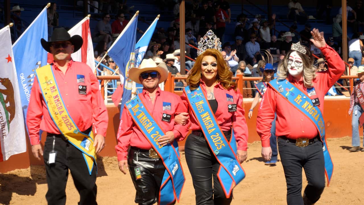 Four people wearing red shirts, leather pants and blue pageant sashes that read "Miss NMGRA 2025." Two people on the left are wearing cowboy hats and two people on the right are wearing crowns.