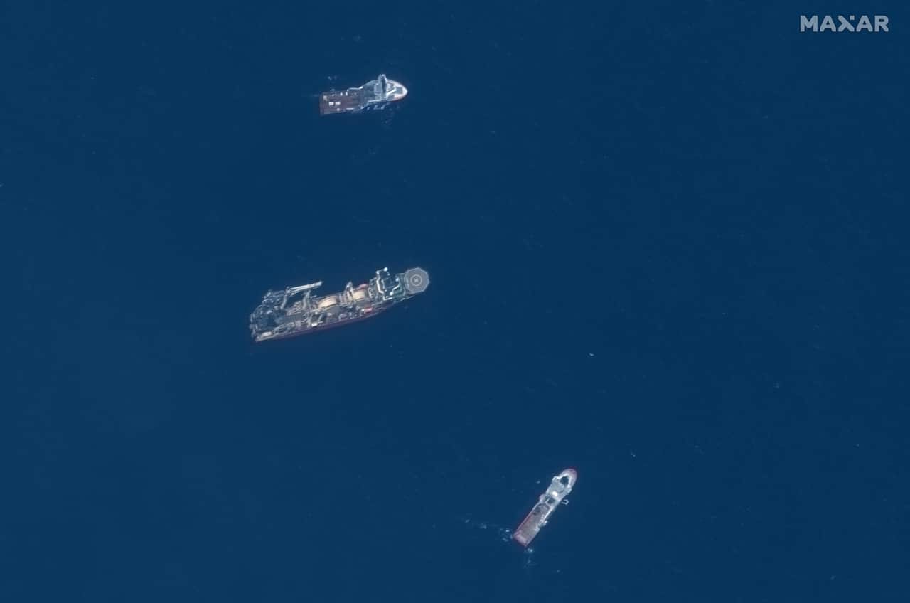 An aerial view of three large ships on the ocean's surface.