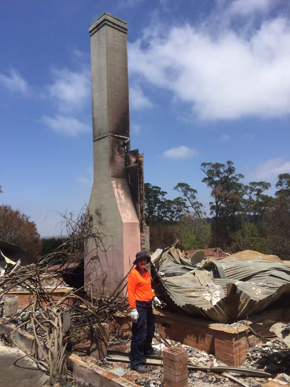 A chimney standing amongst the ashes and rubble of a house