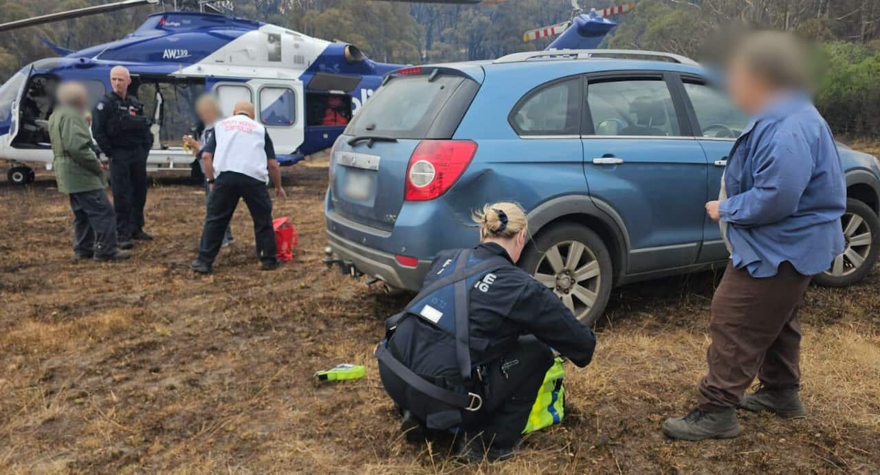 Police officers and emergency officials are seen around a car