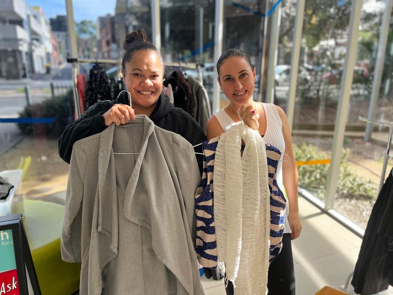 Two women holding clothes