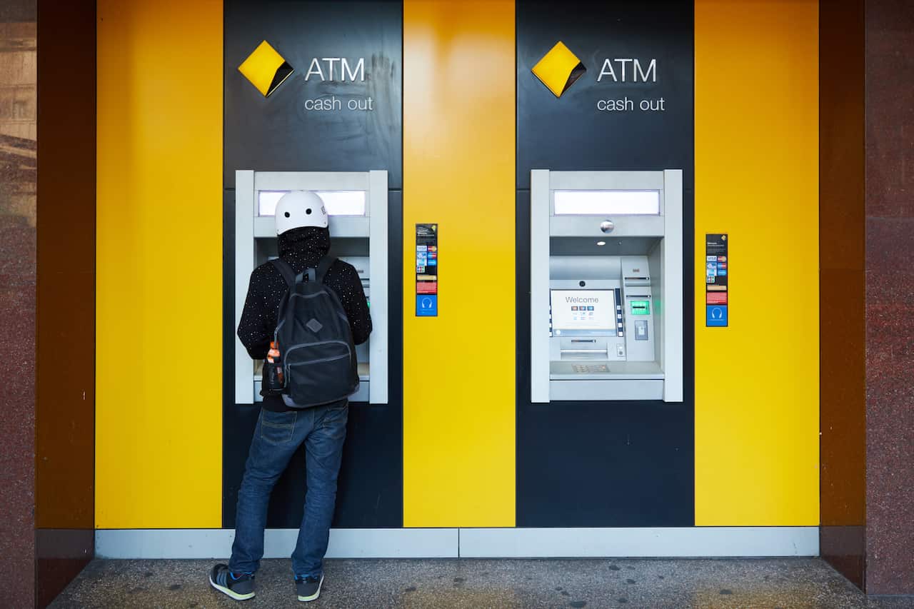 A person withdrawing money from a Commonwealth Bank ATM.