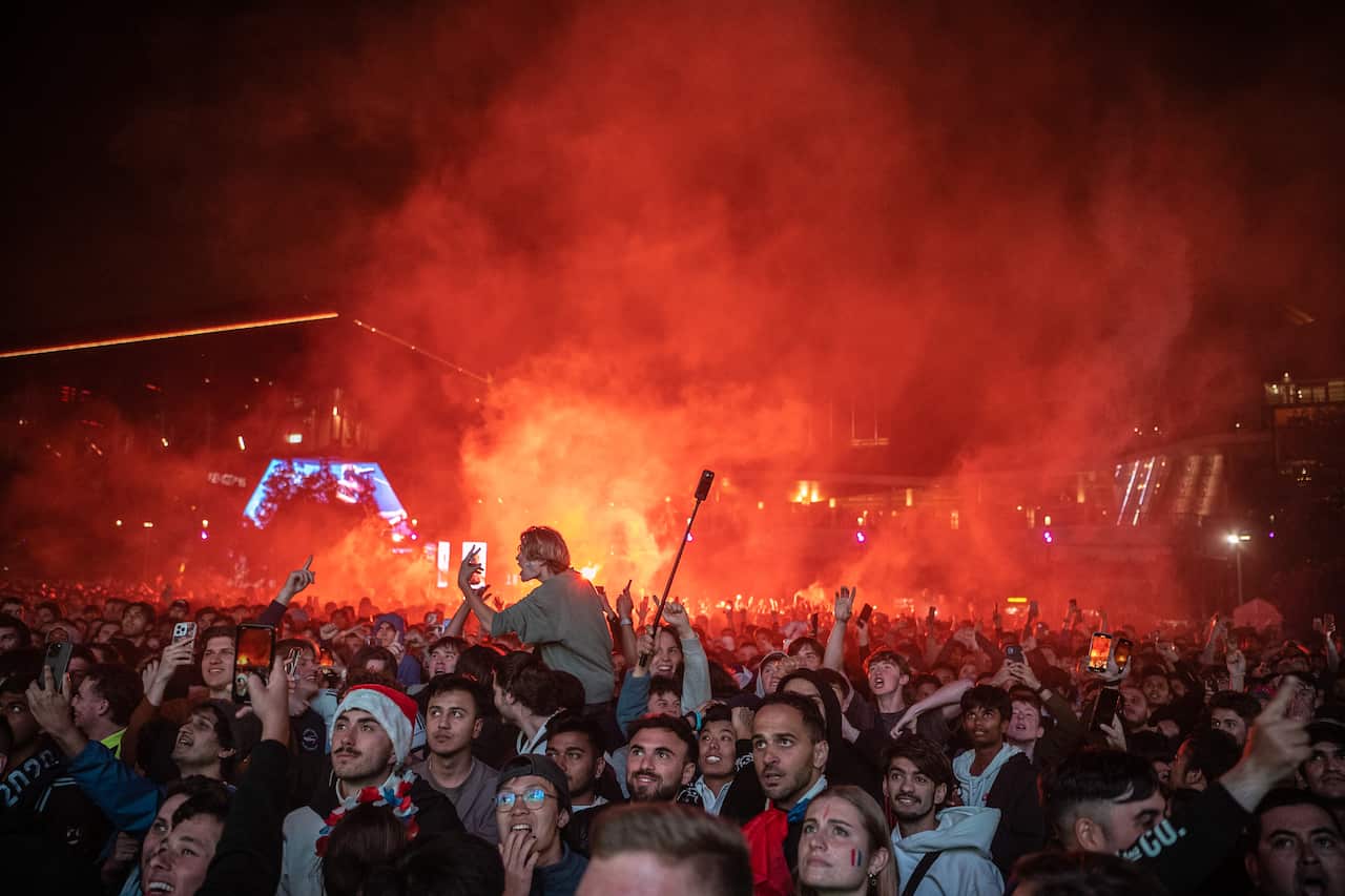 A large crowd of people watching standing outside.