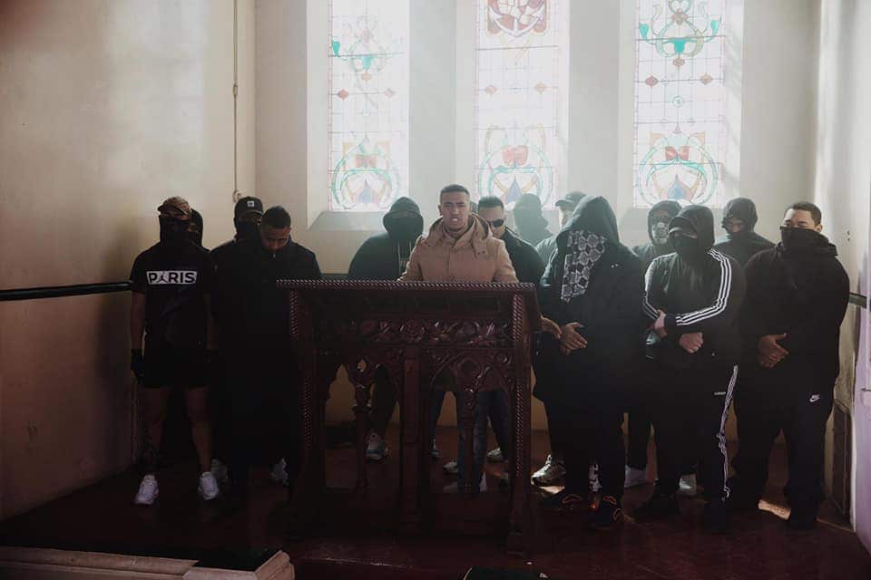 A group of men stand before a podium in a church. 