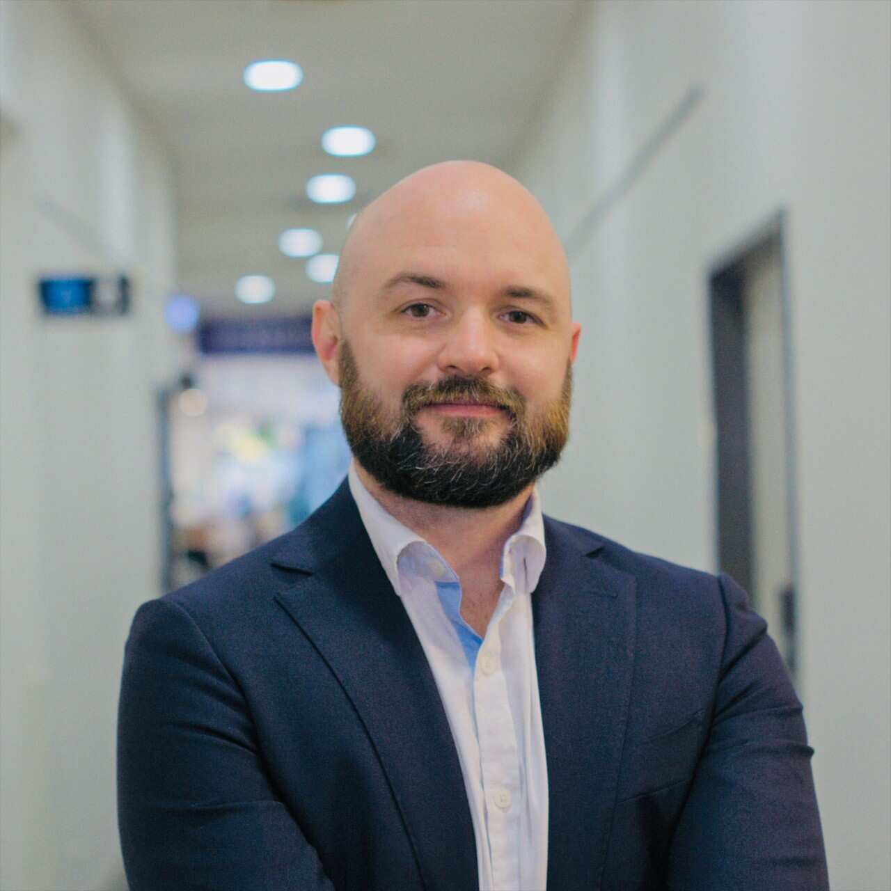 A man in a suit in a corridor. 