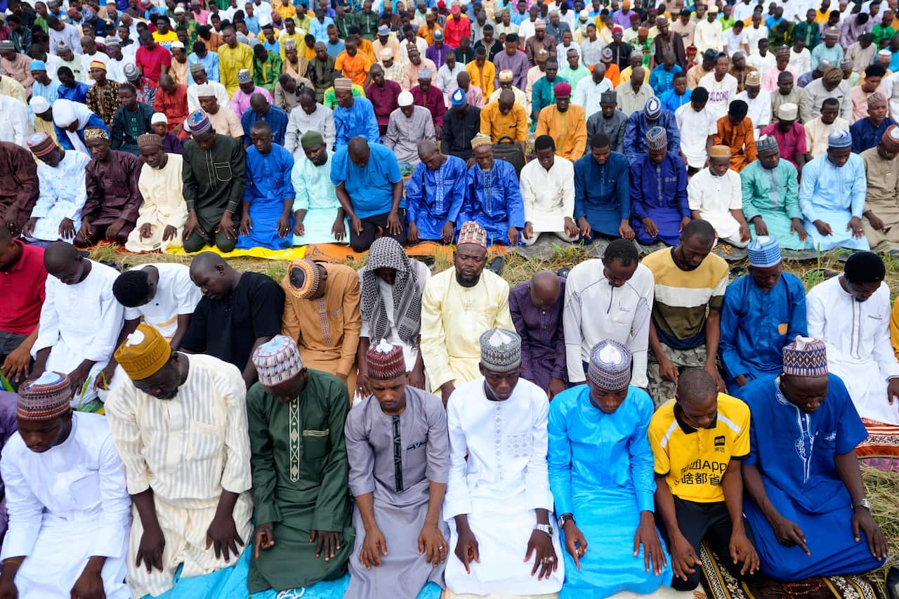 A group of Muslim men outside praying