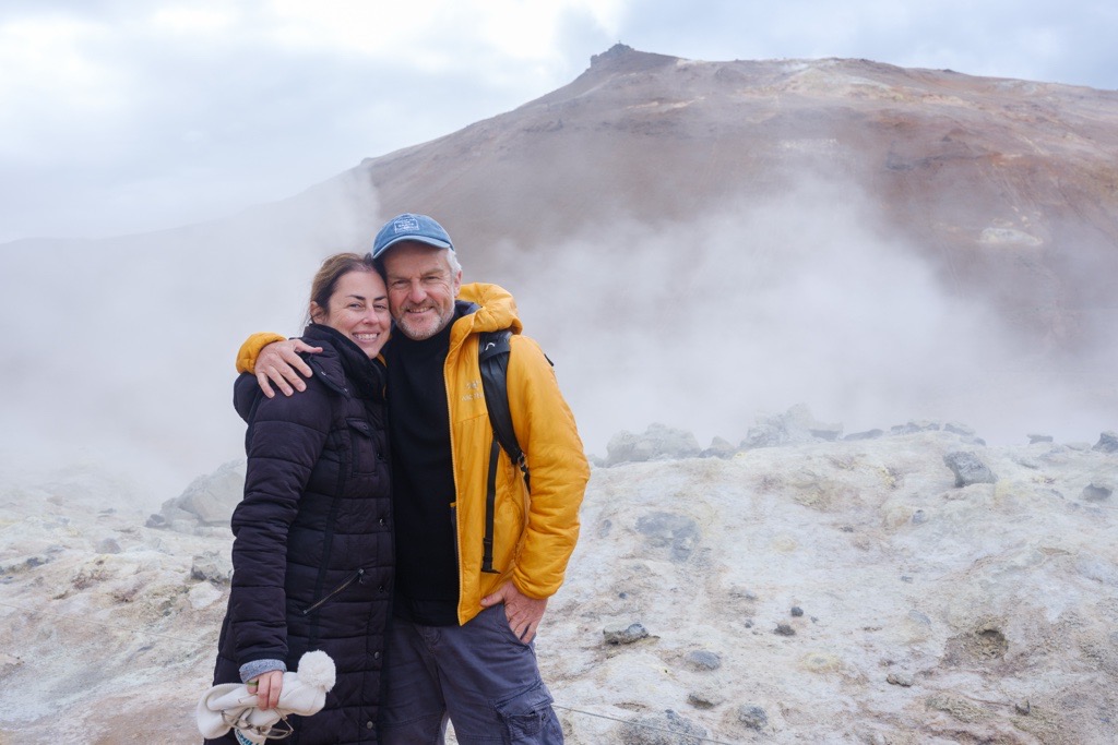 a middle aged couple in front of a waterfall