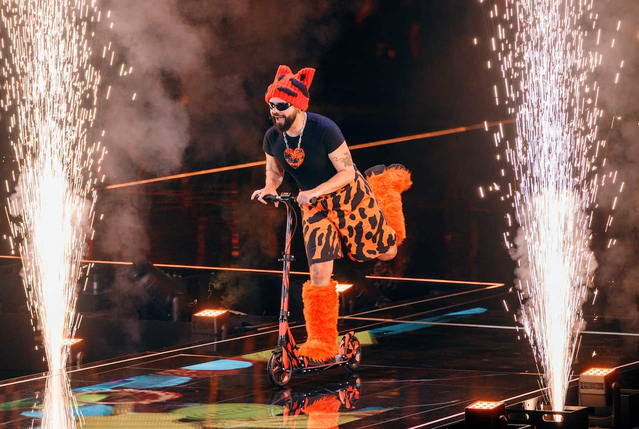A Eurovision contestant riding a scooter on stage.