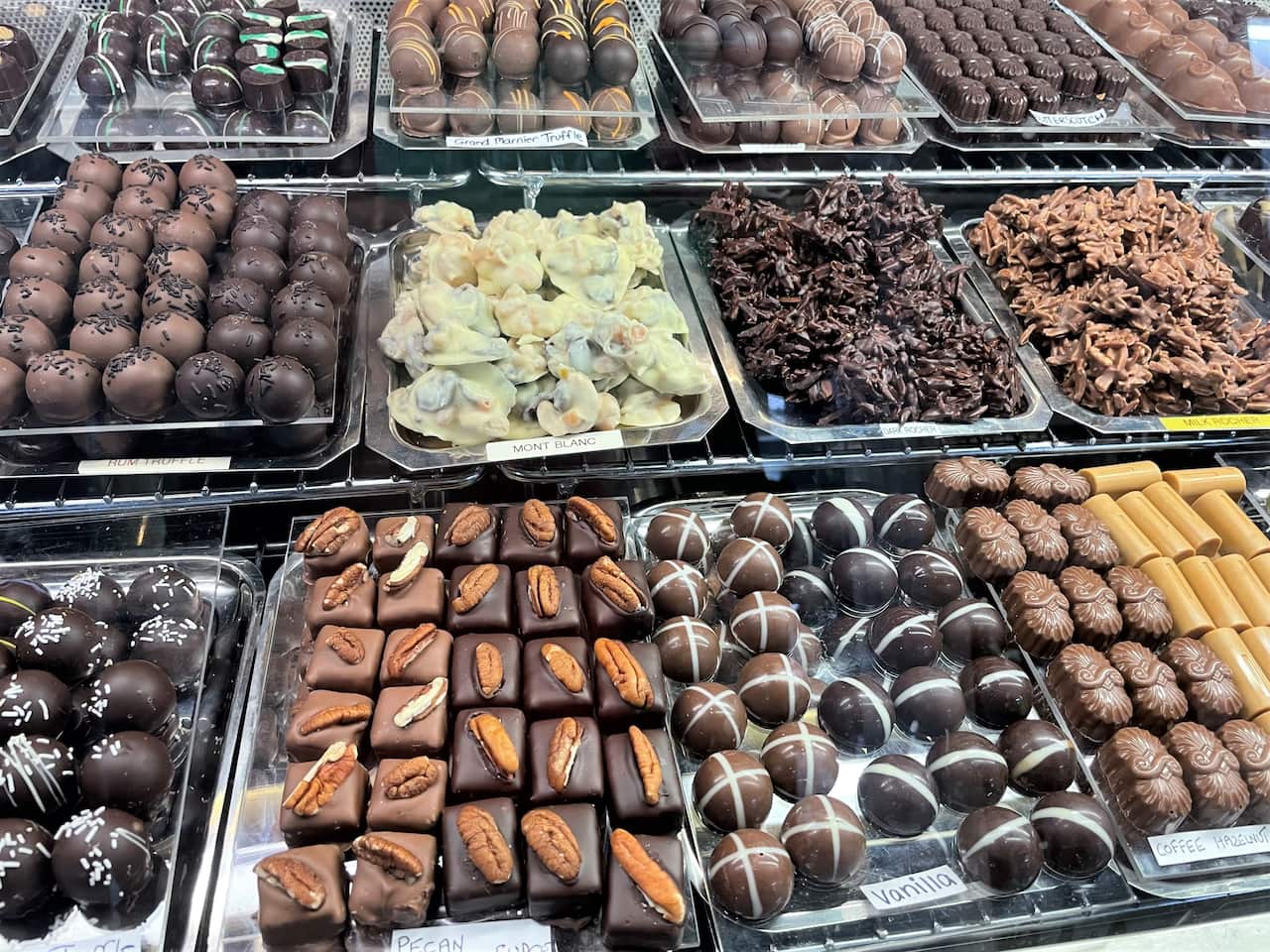 Trays of chocolates behind a display counter in a shop 