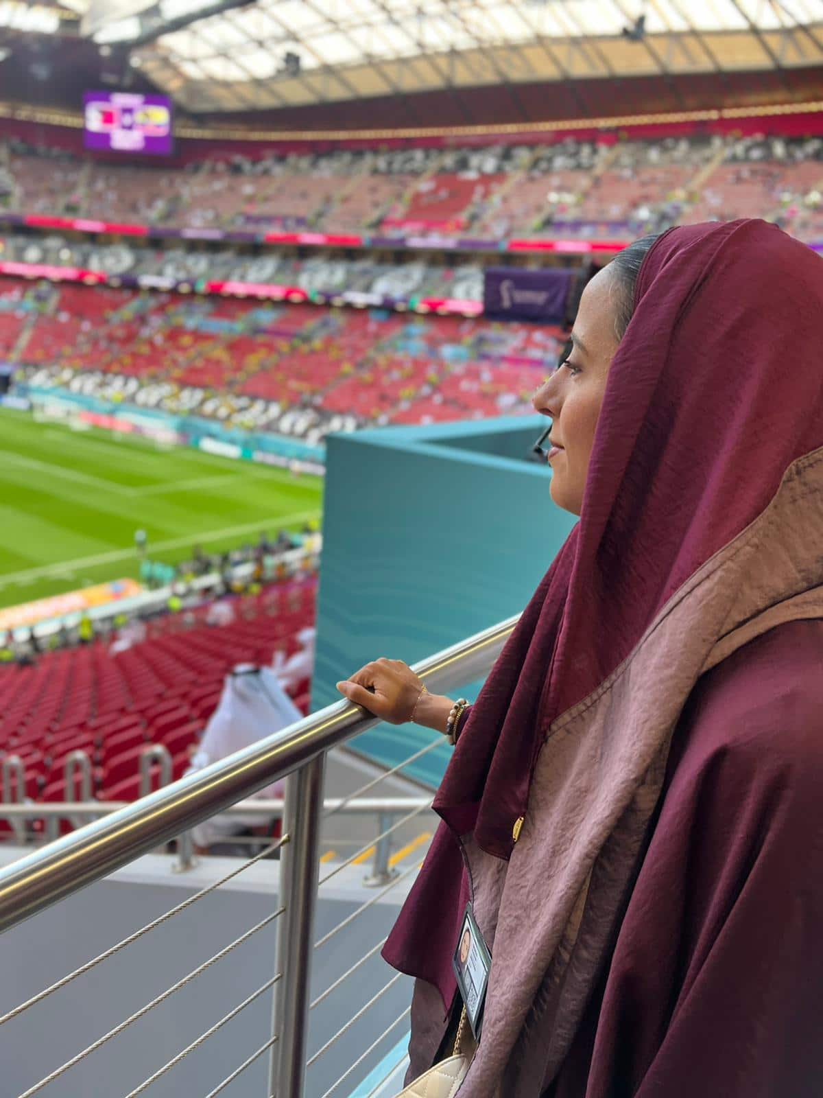 A woman in a burgundy headscarf in a football stadium