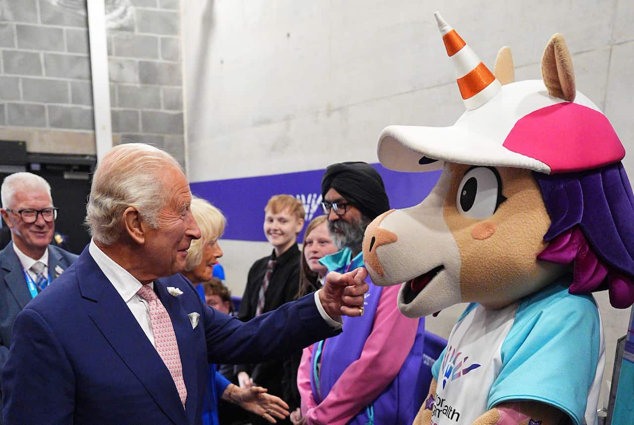 King Charles meeting a unicorn mascot.