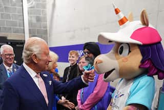 King Charles meeting a unicorn mascot.