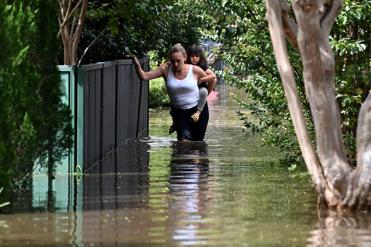 Residents wade through floodwater in Windsor, northwest of Sydney, Wednesday, 9 March 2022.