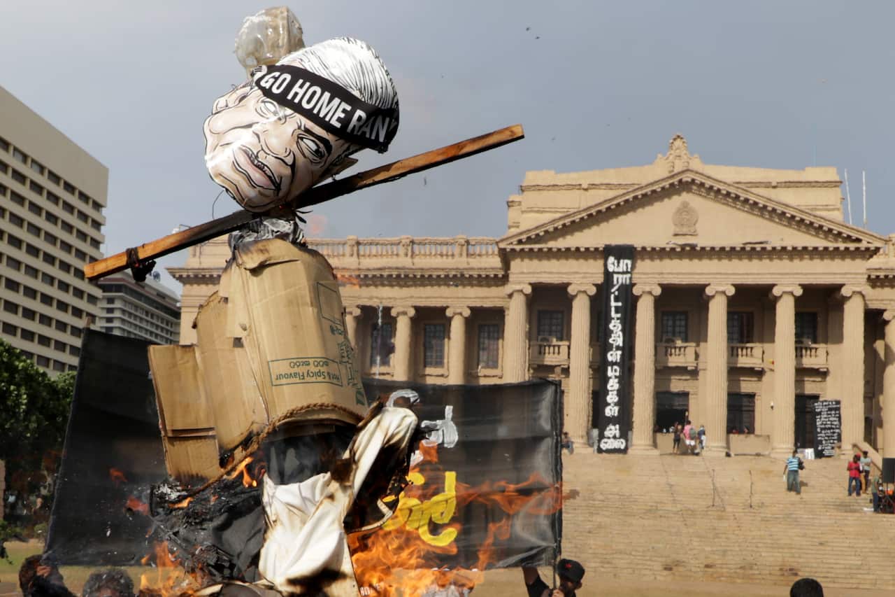 Sri Lankan anti-government protesters burn an effigy of acting president Ranil Wickremesimghe