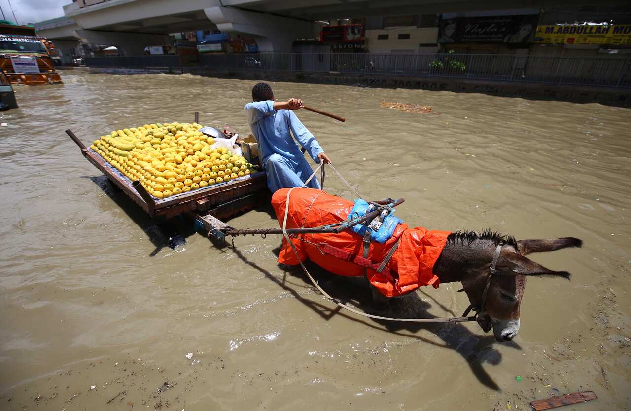 People make their way through a flooded area.